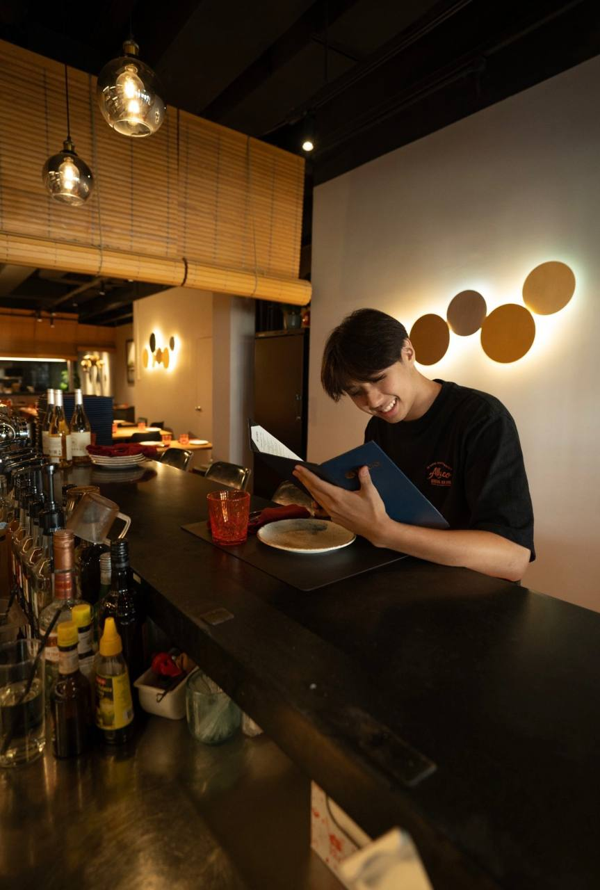 Reading a menu at the bar of one of the venues, before service