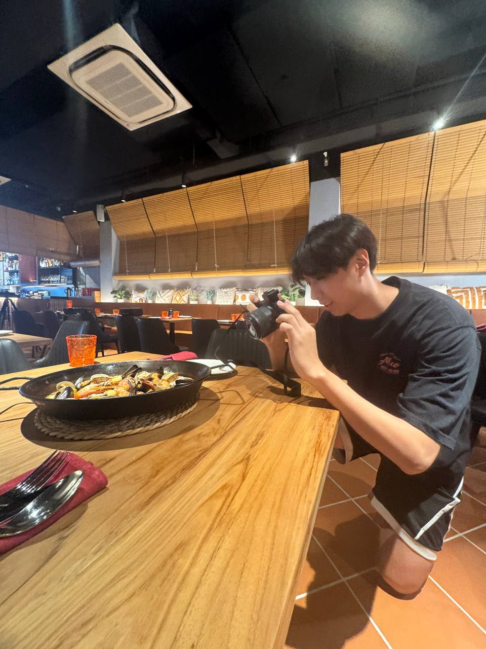 Kneeling to photograph a seafood paella at table height